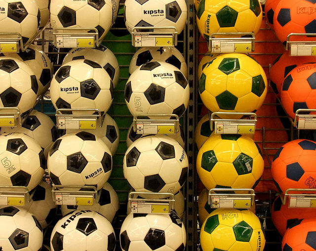Photo of different coloured footballs on wall