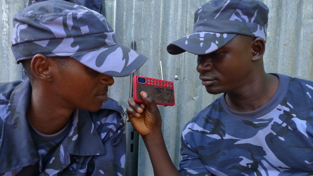 Two police officers in Sierra Leone listen to a radio