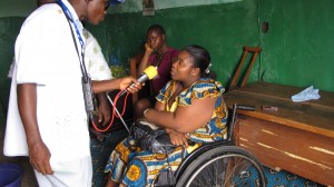 Radio journalist interviews woman in a wheelchair