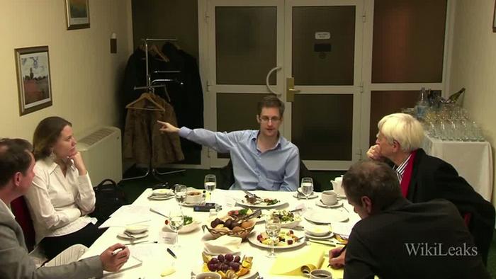 Photo of Edward Snowden sitting at a table together with others