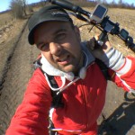 Michael Wigge trägt seinen Tretroller über einen schlammigen Feldweg