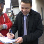 Ein Mann unterschreibt eine Petition von Michael Wigge