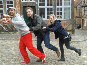Michael Wigge, Steffen Thamm und Dietke Studemund in Tretroller-Pose vor einem Fachwerkhaus