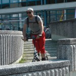 Michael Wigge fährt auf dem Tretroller durch eine Stadt