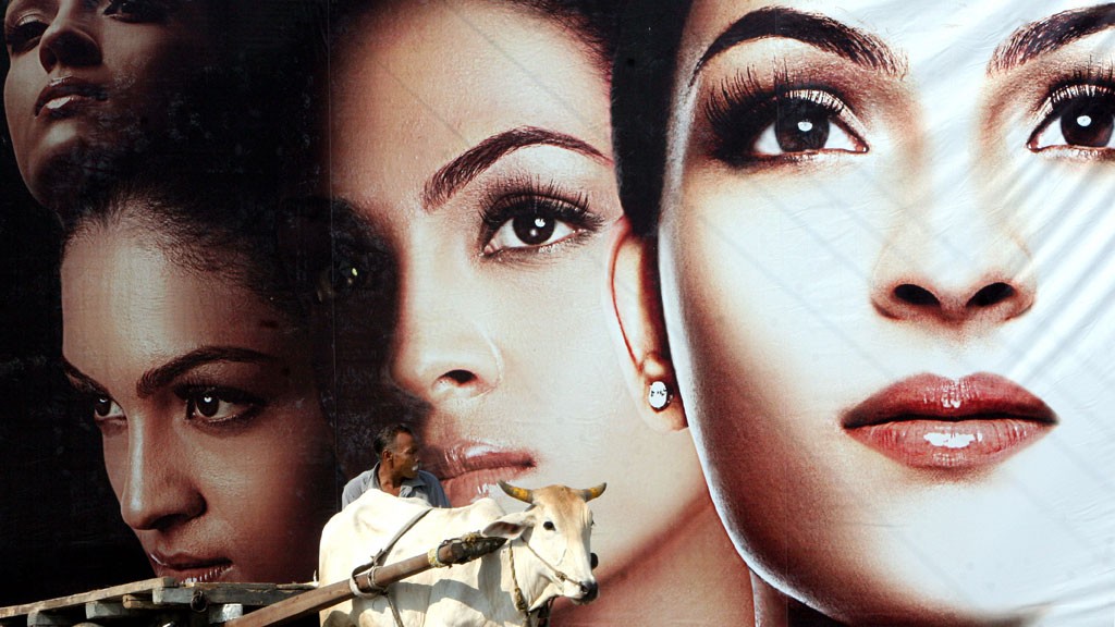 A man walks in front of an ad for skin-brightening product © picture-alliance/dpa/S. Sen