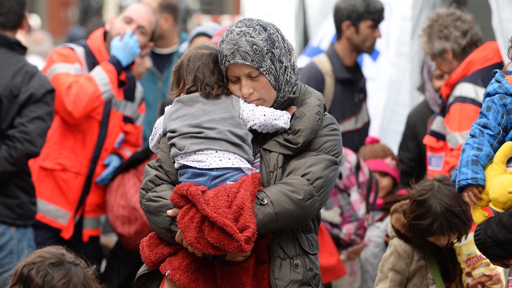 Migrant mother with a child waits for a first medical check after their arrival at the main railway station in Munich, southern Germany, on September 06, 2015.  @ Getty Images/AFP/C. Stache